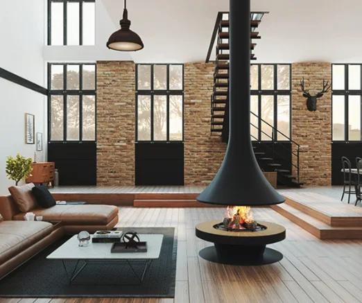 A suspended fireplace in a loft with tall industrial windows
