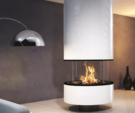 A round open hearth with a hanging hood against a dark feature wall