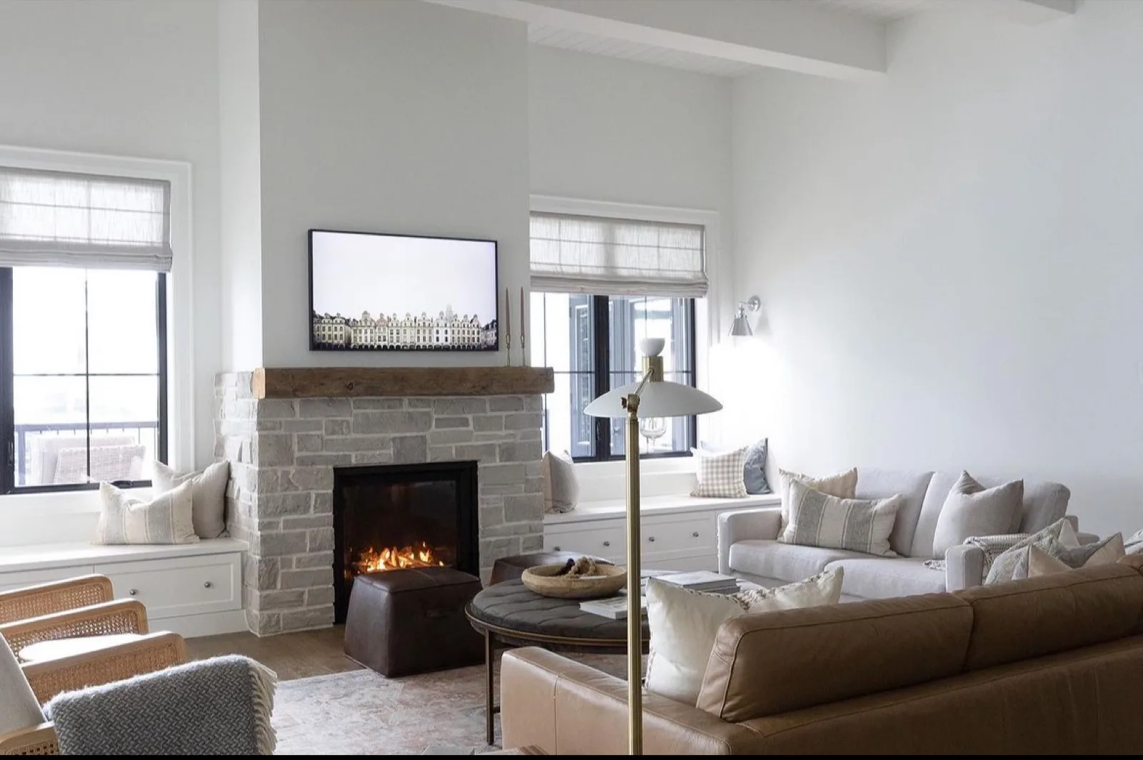 A freestanding gas stove on a stone hearth warming a cream-toned living room