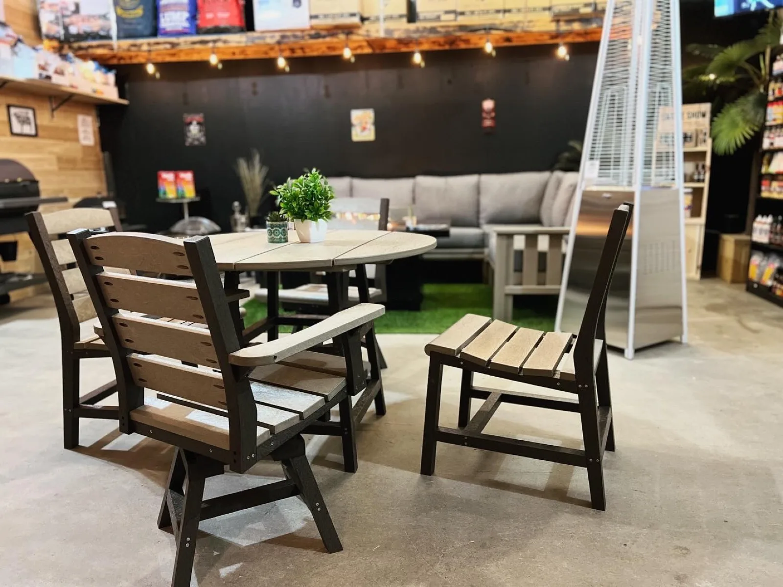A patio furniture set staged in the Classic Stoves & Fireplaces showroom under string lights