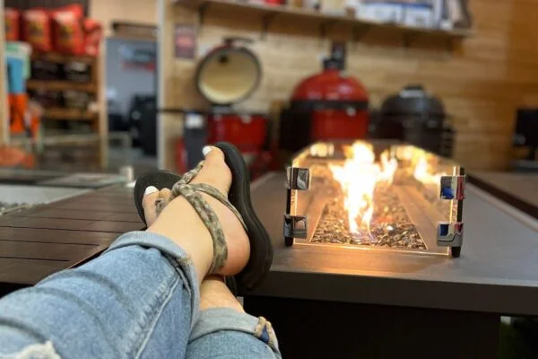 Feet up beside a burning fire table on the patio