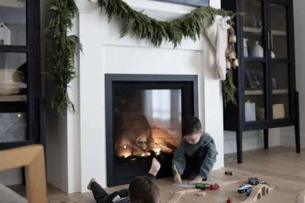 A gas fireplace burning in a classical mantel in the Classic Stoves showroom